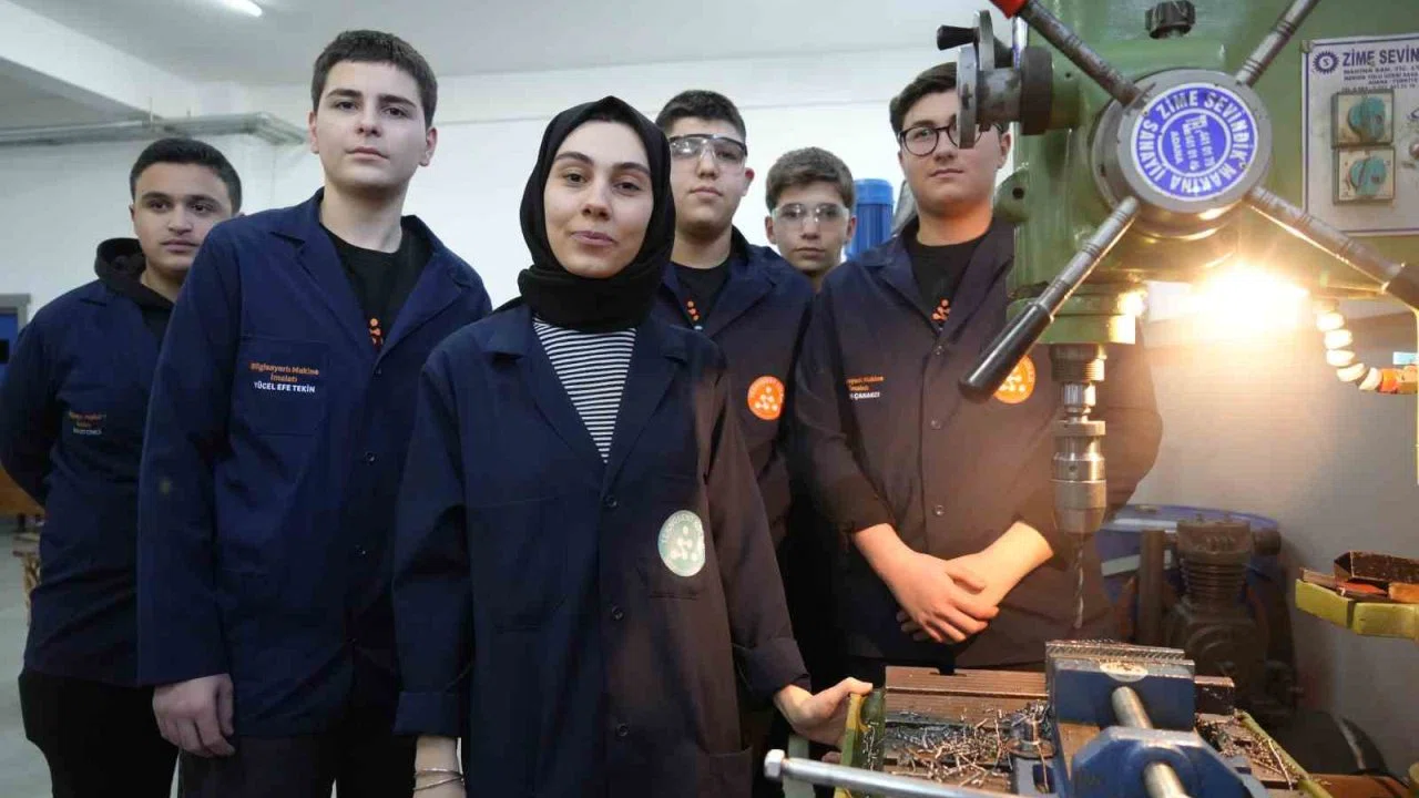 Kadın öğretmen torna tezgahında öğrencilerine üretimi öğretiyor