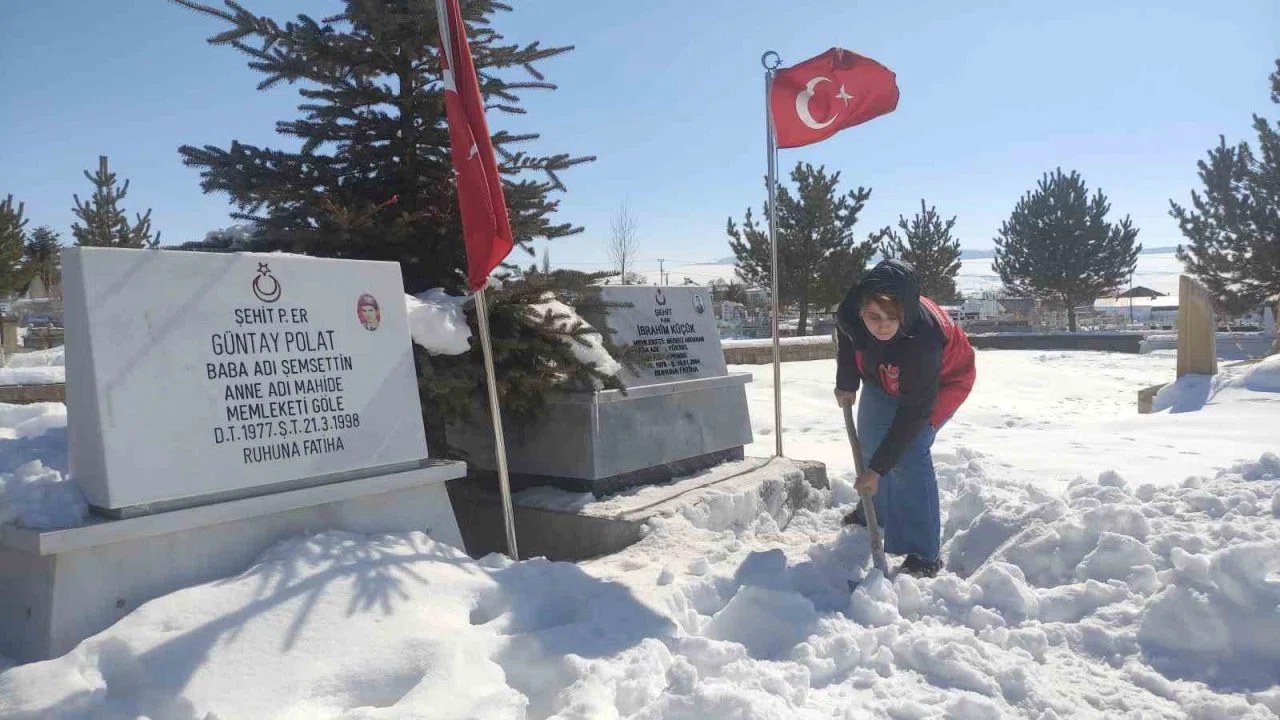 Karla kaplanan şehitlikte temizlik yaptılar