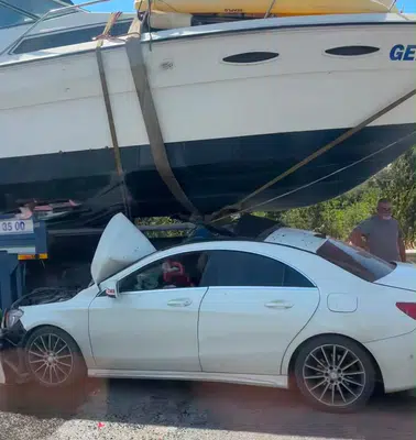 İzmir otoyolunda şaşkına çeviren manzara: Otomobil teknenin altına saplandı