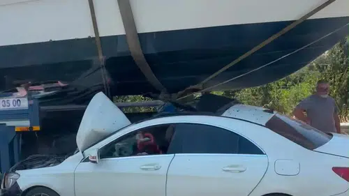 İzmir otoyolunda şaşkına çeviren manzara: Otomobil teknenin altına saplandı